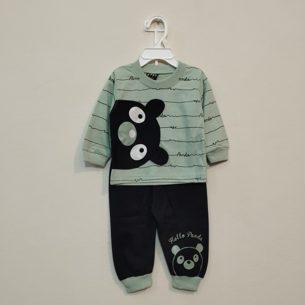 Children's pajama set with panda design on a beige background