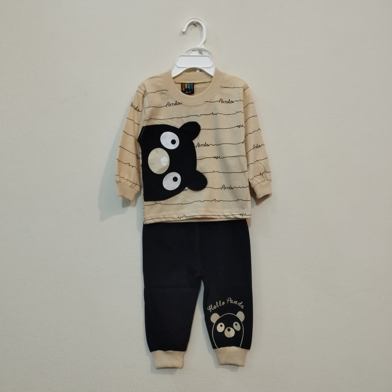 Children's pajama set with panda design on a hanger against a plain background